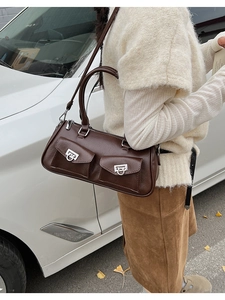 Detail of dark brown leather Boston bag with silver horsebit hardware and front pockets