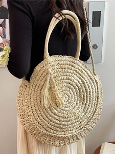 Handcrafted round straw woven shoulder bag with tassels for summer beach vacation style
