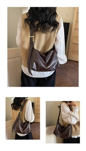 Detail of dark brown leather bag showing wide strap with square golden buckle