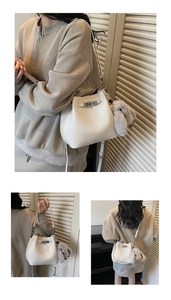 Detail of white leather bucket bag with metal buckle and plush rabbit charm accessory