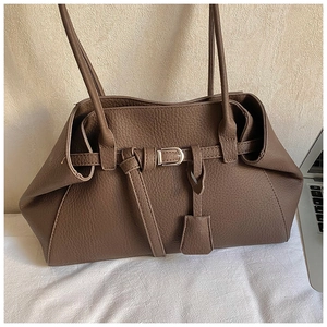 Detailed close-up of retro brown lychee texture leather tote with metal buckle and laptop
