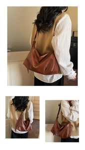 Detail of soft brown leather tote bag with wide adjustable strap and golden buckle