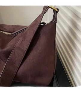 Nahaufnahme der braunen Wildledertasche mit goldenem Reißverschluss und Textur