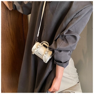Mini bolso bandolera blanco cilíndrico con acabado pulido y diseño de letras negras