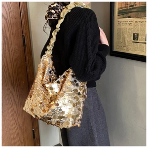 Detail of large gold sequin tote bag with trendy ruched shoulder strap design