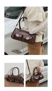 Detail of vintage brown bowling bag featuring front pockets and metallic horseshoe buckles