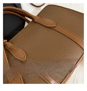 Gros plan sur le sac cabas marron avec texture cuir litchi et détails de coutures soignés