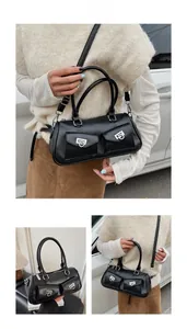 Detail of black leather Boston bag featuring double pockets and metallic horse-shoe buckle
