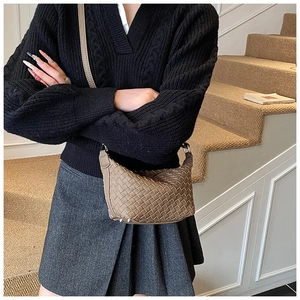 Detailed view of woven faux leather texture and protective studs on brown hobo bag
