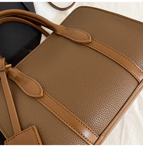 Détail du sac cabas en cuir marron avec texture grainée et coutures de qualité