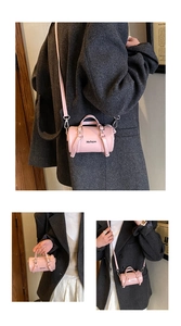 Mini bolso cilíndrico rosa con texto Hellojm mostrado en bandolera y estilos de mano