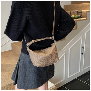 Detail of khaki woven leather hobo bag showing the adjustable strap and metal hardware