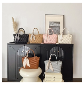 Quilted tote bags with silk scarf handles in various colors on display