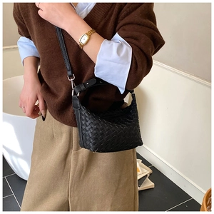 Detail of a black hand-woven hobo bag with adjustable shoulder strap and leather texture
