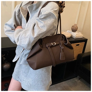 Detail of a vintage dark brown matte leather shoulder bag with buckle and long straps