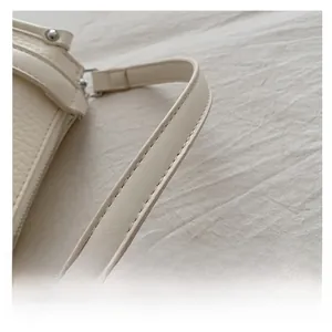 Detailed macro view of the cream lychee grain leather handle with fine double stitching