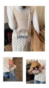 Detalle de mini bolso cilíndrico plateado con acabado metálico y logo impreso