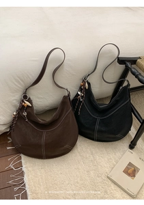 Détails de sacs hobo en cuir mat avec surpiqûres contrastées et breloques ethniques