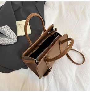 Détails du sac cabas en cuir marron à grain litchi avec poignées et bandoulière amovible