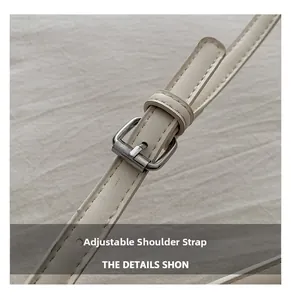 Detail of adjustable cream leather shoulder strap with silver buckle and fine stitching