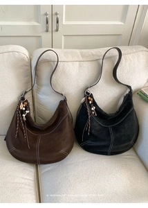 Détails des sacs hobo en cuir mat avec coutures contrastées et pendentifs à pompons