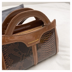 Close-up of snake pattern leather texture and stitching on the brown shoulder bag