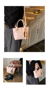 Detail view of pink crossbody bag with colorful beads and adjustable shoulder strap