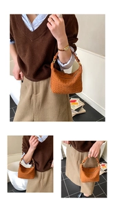 Detail view of the brown woven leather hobo bag showing texture and adjustable metal buckle