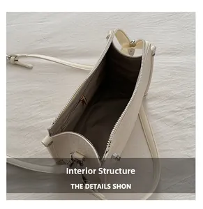 Internal structure of white faux leather bag showing zippered pocket and compartment