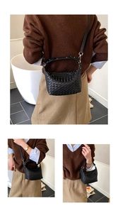 Detail of hand-woven black hobo bag with rivet handle and detachable shoulder strap