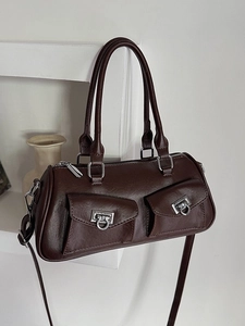 Dark brown leather Boston bag with double pockets and silver metal buckles on a shelf