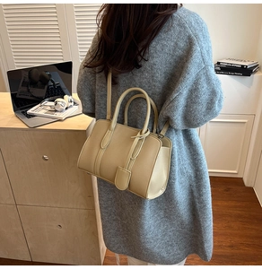 Détail du sac cabas beige avec motif litchi et étiquette décorative sur le côté latéral