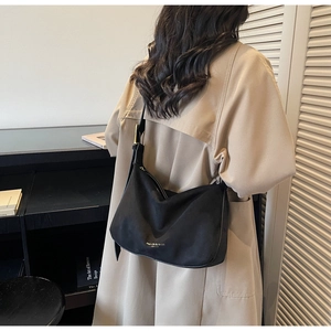 Detailansicht der schwarzen matten Hobo-Tasche mit Goldlogo und verstellbarem Riemen