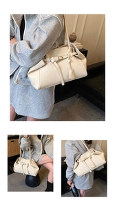 Detail of cream white textured leather shoulder bag with decorative buckle and hangtag