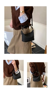 Detail of hand-woven black leather tote bag featuring premium golden metal zippers and hardware
