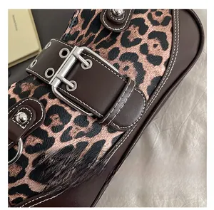 Macro detail of leopard print bag with silver metal buckle and contrast stitching