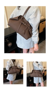 Detail of dark brown lychee leather shoulder bag with silver buckle and trapezoidal folds