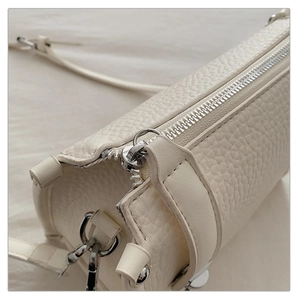 Macro shot of cream lychee texture leather with silver metal zipper and hardware details