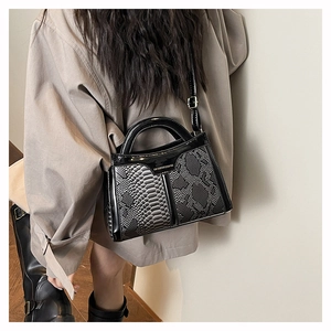 Detail of snake print crossbody bag with fashion text shown on a model's back