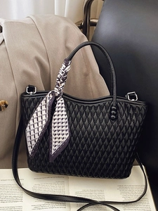 Chic black quilted handbag with diamond pattern and decorative silk scarf on handle