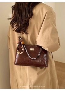 Détail du sac matelassé marron foncé avec boucle argentée et breloque en étoile