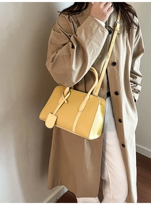 Vue détaillée de la texture du cuir jaune à motif litchi sur un sac à main cabas