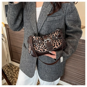 Detail of leopard print handbag with silver buckles on a grey herringbone blazer suit
