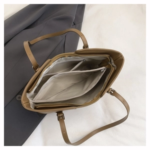 Top view of brown tote bag interior with multiple compartments and zipper closure
