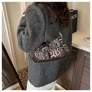 Detailed close-up of retro leopard print handbag with silver buckle and leather trim