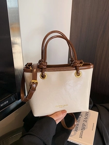 Chic beige and brown leather tote bag with knotted handle and adjustable shoulder strap