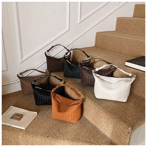 Detailed collection of woven leather dumpling bags in various colors on a staircase