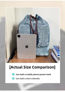 Detail view of washed blue denim backpack with dual front pockets and storage capacity