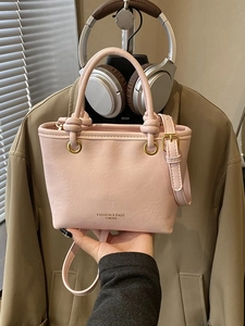 Pink faux leather fashion handbag with golden logo and adjustable shoulder strap