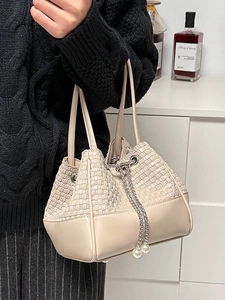 Elegant beige woven leather bucket bag with silver chain and pearl charms for women